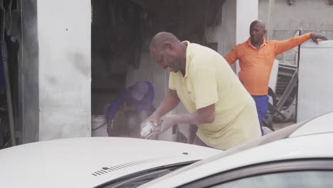 African-man-sanding-a-car