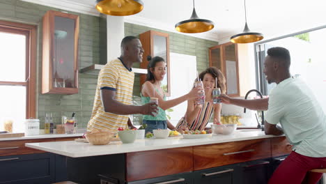 diverse friends enjoy drinks at a home kitchen