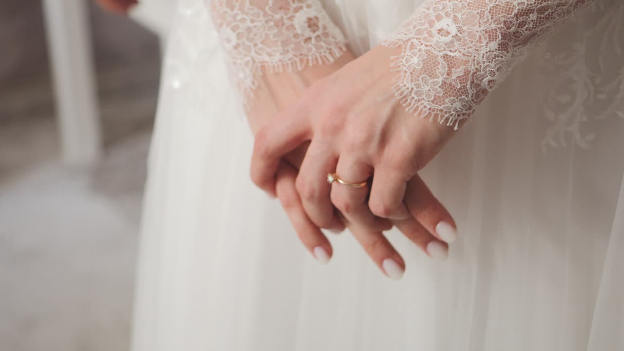 Bride's hands in lace, wedding dress details, elegant, serene mood