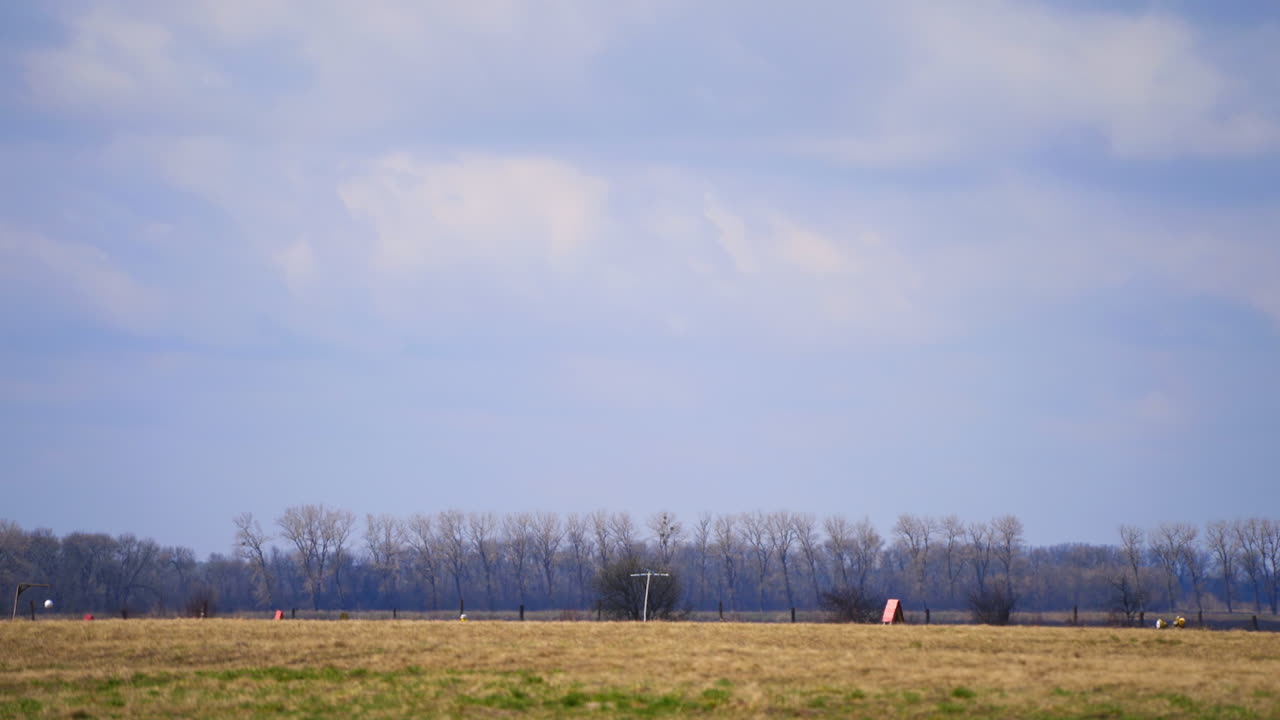 Little light aircraft is taking off from the empty aerodrome. Airplane departure in autumn landscape.