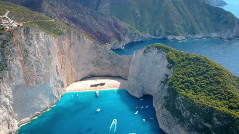 breathtaking aerial view of crystal clear blue water of navagio beach, surrounded by huge cliffs and mountains, zakynthos, greece