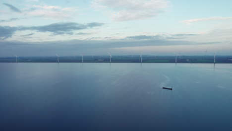 Vista-Del-Lago-De-Otro-Mundo-Con-Turbinas-De-Viento-Esparcidas-Por-El-Horizonte