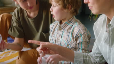 little boy helping lesbian mothers with sorting waste at home
