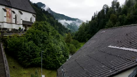 slovenia small town surrounded by misty pine forest mountains aerial drone 2
