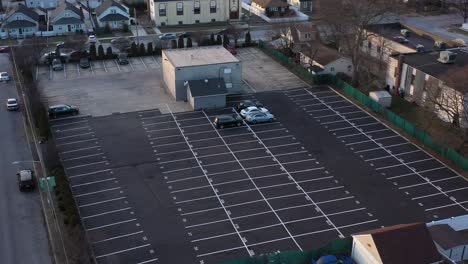 una vista aérea de un lote de almacenamiento de un concesionario de automóviles al atardecer