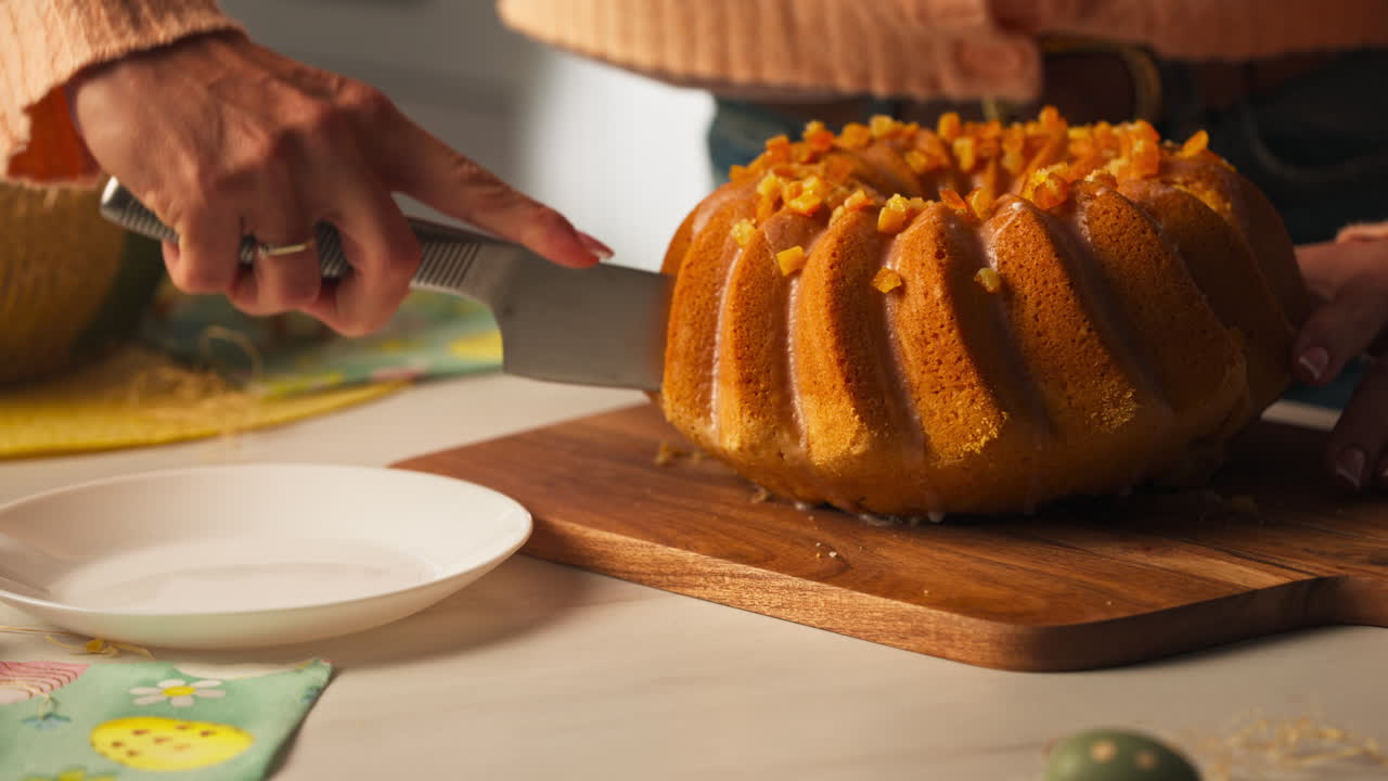 Slicing Orange Bundt Cake On Wooden Cutting Board In The Kitchen. close-up shot