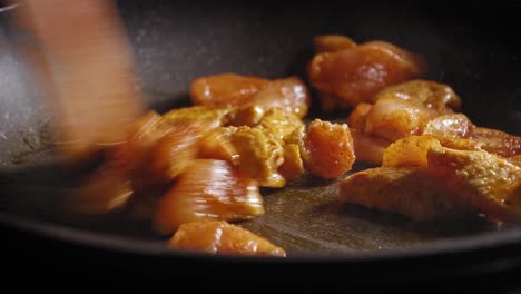 seasoned chicken breast cooking and stirring in a pan