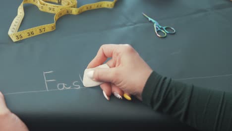 writing fashion designer on fabric textile in chalk