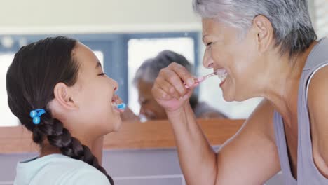 abuela y nieta cepillándose los dientes en el baño 4k
