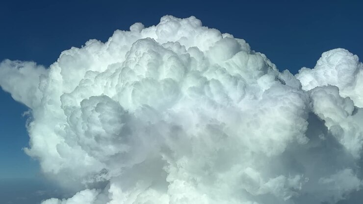Closeup view of the top of a huge cumulonimbus cloud, shot from a jet cockpit while flying at 12000m high