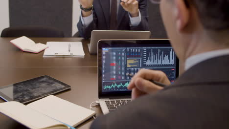 data analysts sitting in meeting room and working together with laptop with statistics