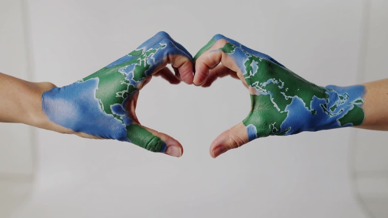 Mani dipinte con la mappa del mondo che si muovono verso l'interno, pollici e dita che si incurvano, formando un cuore per l'ambiente.
