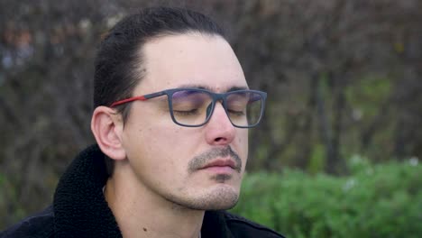 primer plano de un hombre joven, cansado y molesto con gafas