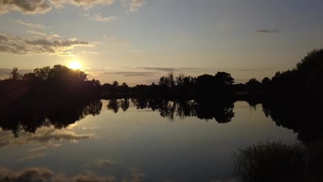1 millón de $ control deslizante de vuelo de drones aéreos vuela de lado al atardecer de verano en un lago en un pequeño pueblo en brandeburgo, alemania