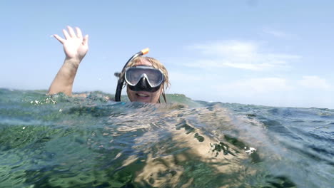 woman in snorkel sending greeting from the sea