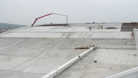 panning view of construction on the rooftop of a industrial factory job site