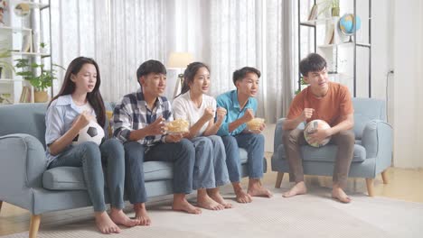 친구 들 이 집 에서 축구 경기 를 보고 있다