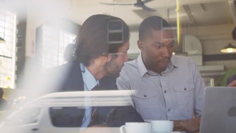 three businessmen meeting in coffee shop shot through window