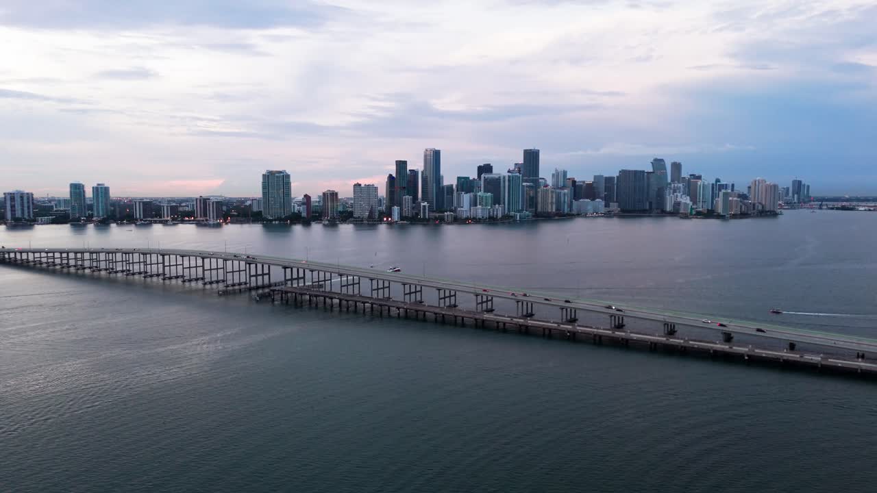 Drone shot of Miami and William M Powell bridge from Virginia Key at dusk