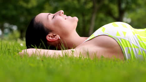 Pretty-brunette-lying-down-on-the-grass