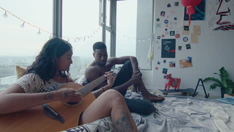 girl playing the guitar and chilling with boyfriend in bedroom