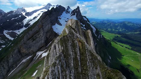 4k drone aerial closely flys above jagged rock peaks at shäfler ridge in appenzell region of switzerland