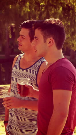 amigos felices en el parque tomando cervezas