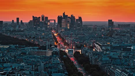 aerial drone footage of france, paris city during sunset or sunrise that is golden orange and yellow colored during dusk or dawn. cars and vehicles driving on the roads with headlight on, skyscrapers.
