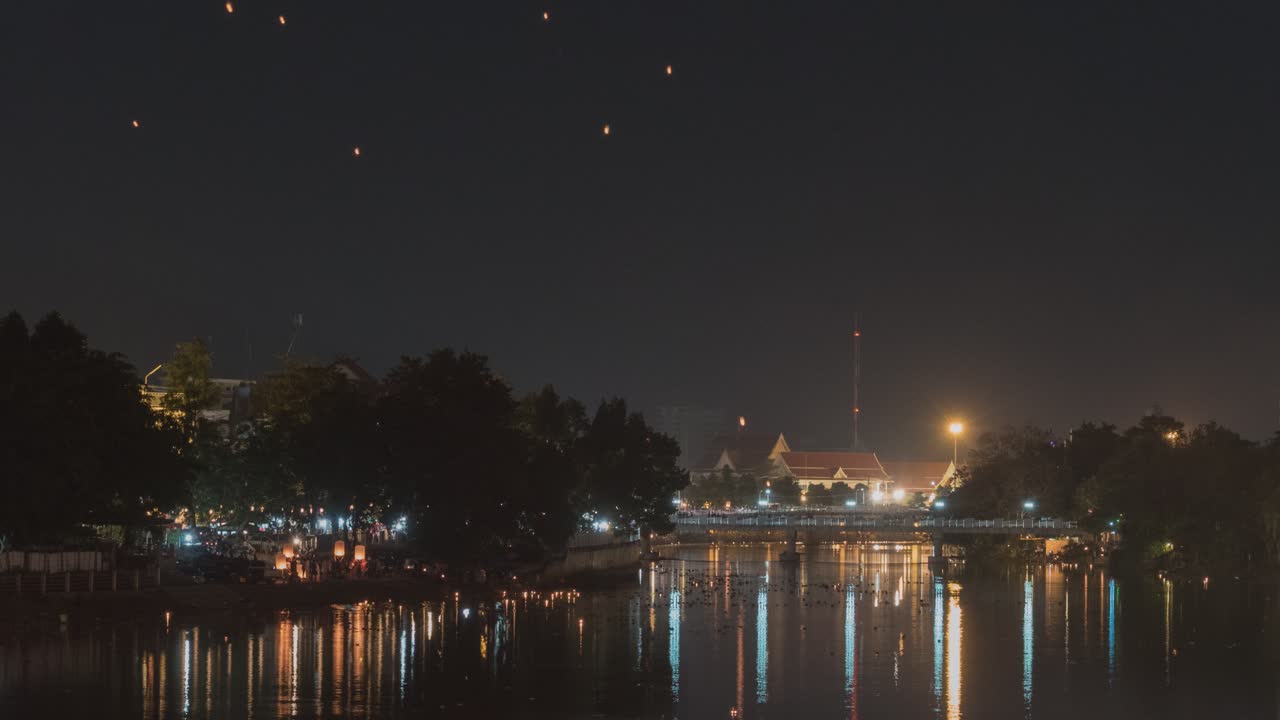 Nighttime view of a river and city, possible lantern festival