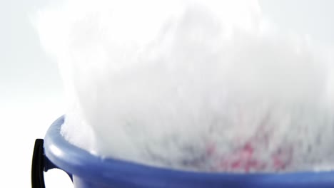 Cleaning sponge falling in to bucket of soap suds