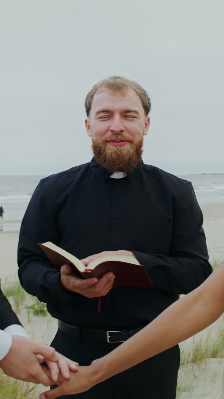 Wedding ceremony on the beach with priest officiating