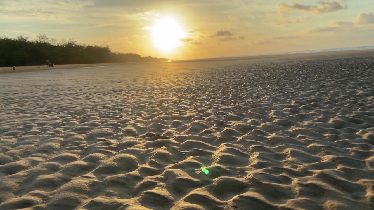 Gylden solnedgang over kruset sand på en fredfyldt strand