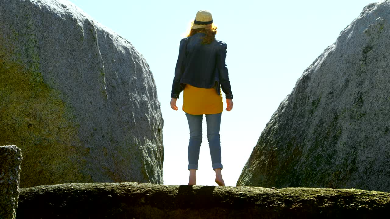 해변 4k에 있는 바위 위에 서 있는 여자