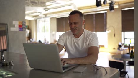 Hombre-De-Negocios-Sonriente-Trabajando-En-Una-Computadora-Portátil-En-La-Oficina-Del-Hogar.-Profesional-Masculino-Escribiendo-En-El-Teclado-De-Una-Computadora-Portátil-En-El-Lugar-De-Trabajo-De-Oficina