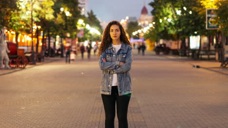 woman standing in city street at night