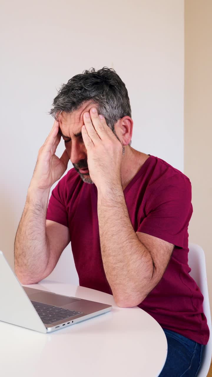 Tired Man Experiencing Eye Strain and Headache While Working on Laptop