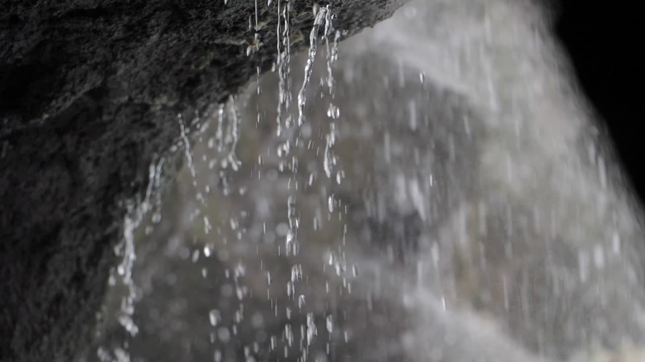 Water dripping from a rock into a waterfall
