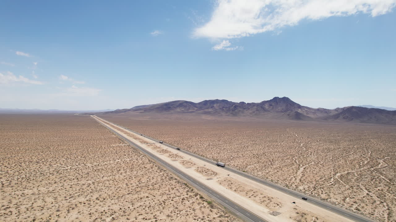 황무지 를 가로지르는 다차선 고속도로 를 운행 하는 차량 들 의 공중 사진