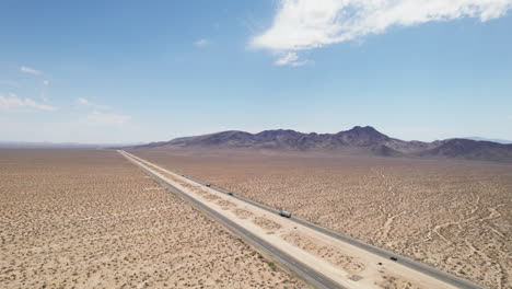 aerial view of vehicles driving on multilane motorway leading through deserted land