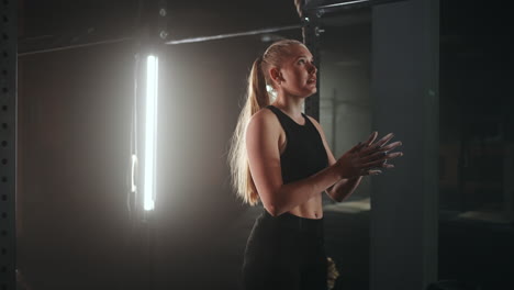 full length wide angle shot of a woman performing rope climbs at the gym. athletics healthy composition. cross fitness. determined athletic woman moving up the rope in a gym.