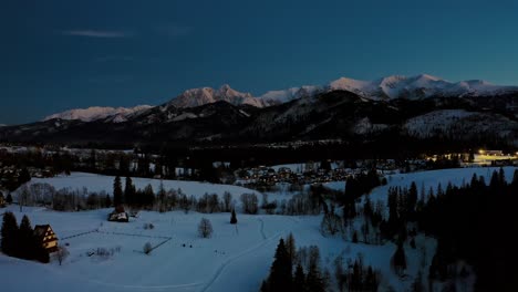 blue hour traditional polish village kościelisko in winter with mountain backdrop tatry mountains