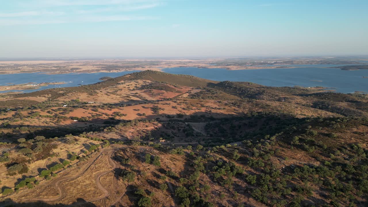 Aerial View of a Scenic Landscape with Hills, Lake, and Vegetation