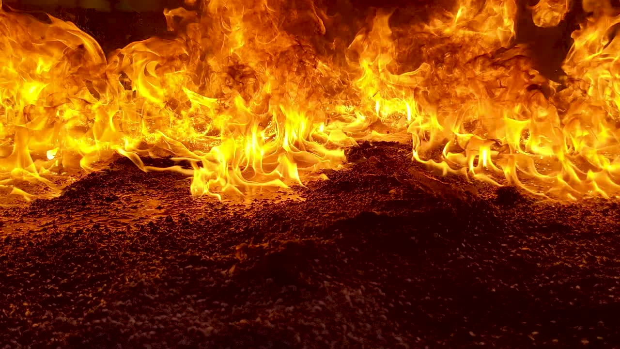 Burning oil on the ground sends thick black smoke into the air