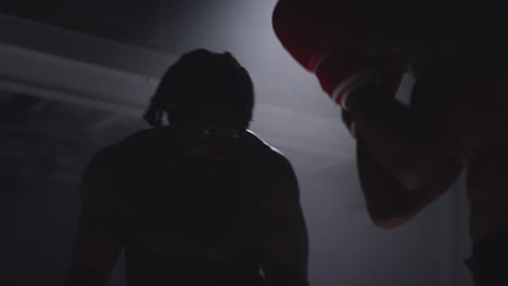 close up shot of two male boxers wearing gloves in boxing ring fighting in boxing match with low key lighting 1