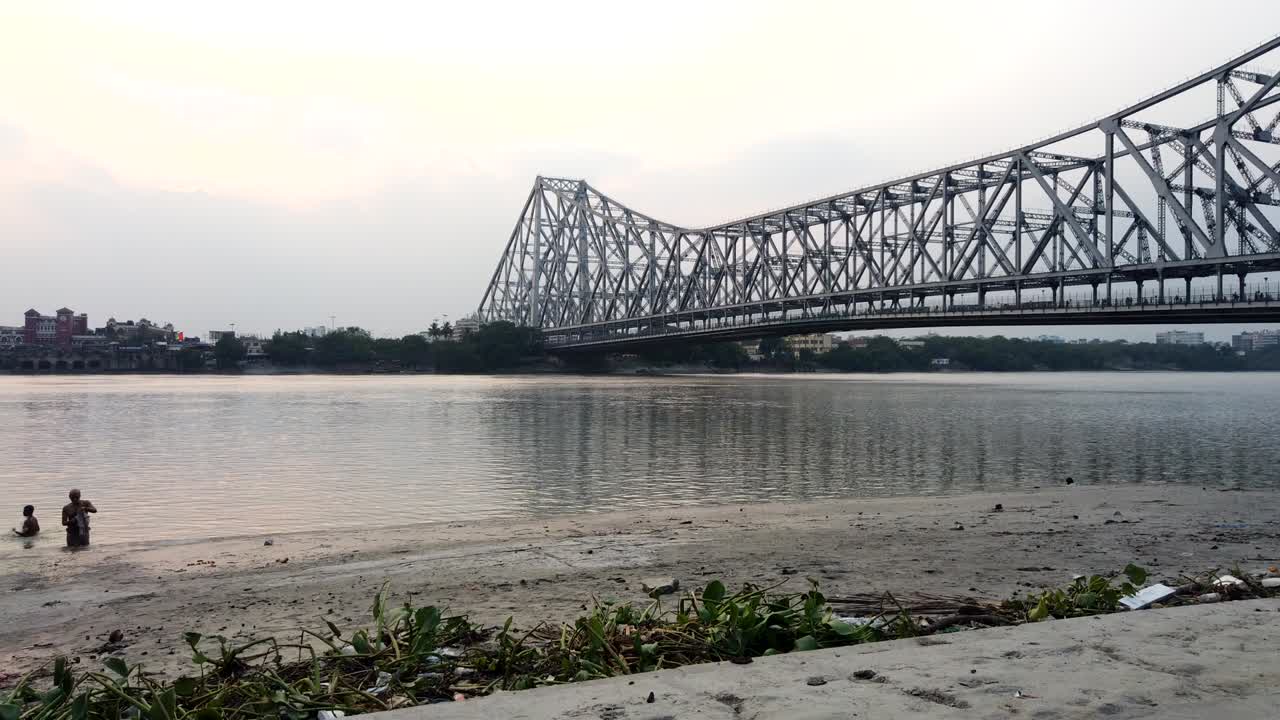 Kolkata : Motion timelapse of the beautiful Howrah Bridge along with old vintage boats passing beneath it.