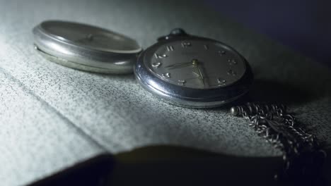 antique pocket watch with silver chain shows time .slow pan close-up