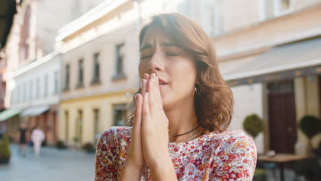 retrato de una mujer orando con los ojos cerrados a dios pidiendo bendición ayuda perdón al aire libre