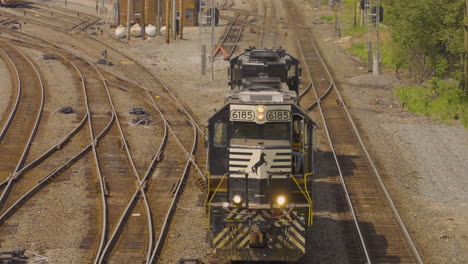 engineer drives engine slowly toward the camera at a railroad intersection