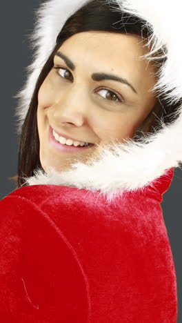 una mujer bonita sonriente posando en un traje sexy de papá noel.