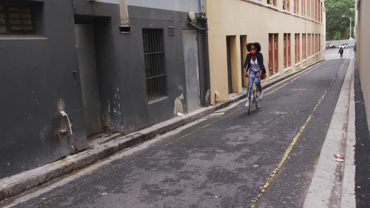 길거리에서 자전거를 타고 마스크를 쓴 아프리카계 미국인 여성